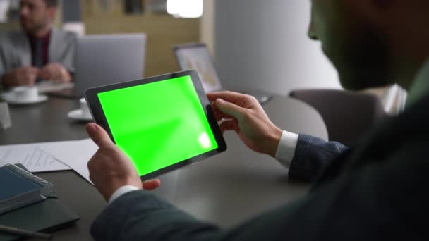 Businessman using tablet device green screen looking corporate news in workplace — Stock Video