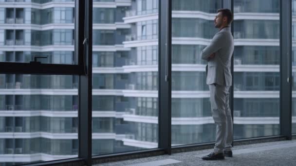Hombre exitoso cruzando las manos mirando la ventana en el centro de oficinas de negocios. — Vídeo de stock