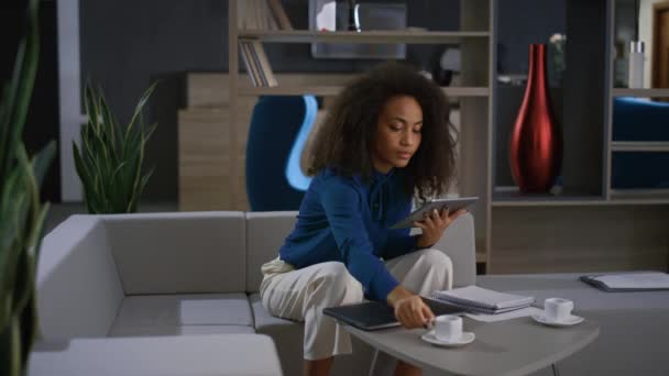 Femme afro-américaine en utilisant la tablette défilant les médias sociaux dans le café de bureau à domicile. — Video