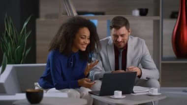 Dizüstü bilgisayarda çalışan iki farklı çalışan. Gülümseyen iş adamları kafede görüntülü sohbet