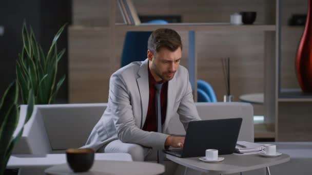 Junger Geschäftsmann arbeitet Laptop Computer wartet Kollegen in abgelegenen Arbeitsplatz. — Stockvideo