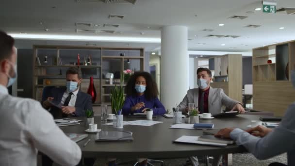 Empreendedores terminam reunião de conferência deixando o escritório usando máscaras coloridas. — Vídeo de Stock