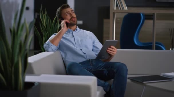 Человек-предприниматель говорит по телефону в офисе. Бизнесмен, использующий поиск ноутбуков в Интернете — стоковое видео