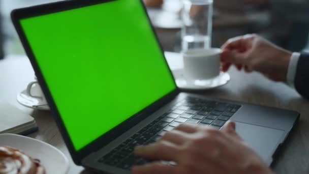Człowiek ręce wpisując klawiatury laptop zielony ekran w kawiarni stół restauracja. — Wideo stockowe
