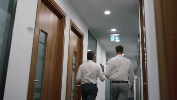 Dos hombres de negocios a pie oficina discutir datos corporativos juntos en la compañía financiera. — Vídeos de Stock