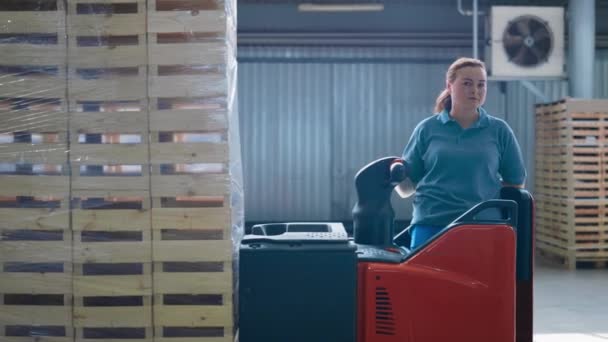 Wanita gudang kerja mengoperasikan mesin penyimpanan mengangkut paket palet — Stok Video