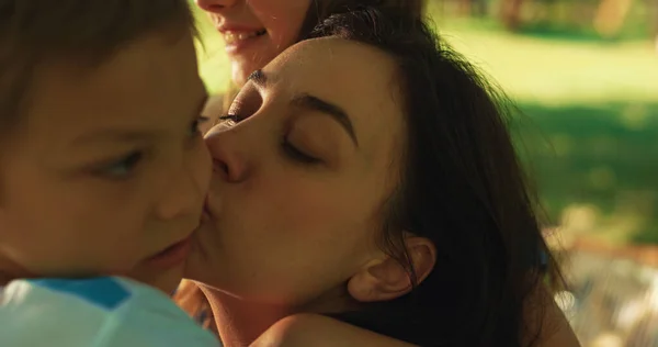 Fond mãe beijando menino no piquenique de perto. Mulher feliz mostrando amor crianças. — Fotografia de Stock