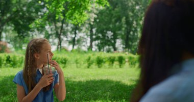 Piknikte içki içen sakin kız. Çocuğun doğada meyve suyu tadı var..