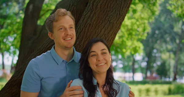 Portret śmiejącej się pary w słonecznym parku. Szczęśliwa para uśmiechnięta przed kamerą zbliżenie. — Zdjęcie stockowe