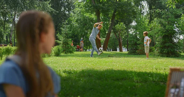Perfil menina assistindo jogo de futebol no parque. Pai jogar futebol com filho. — Fotografia de Stock