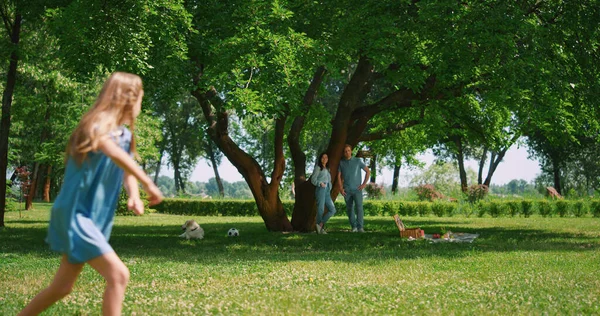 Jolie fille échappant frère sur la pelouse verte. Sœur ludique courir dans le parc en plein air. — Photo