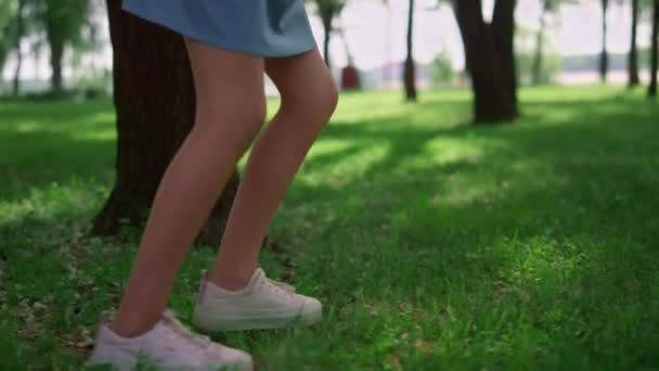 Courir les jambes des enfants sur la prairie d'herbe verte. Les enfants inconnus jouent au jogging à l'extérieur. — Video