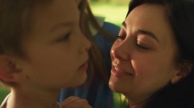 Oğluyla oynayan genç bir kadının portresi. Yakın çekim. Anne dokunaklı erkek burnu.