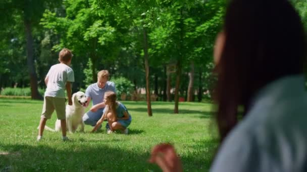 Mulher assistindo família brincar com cão no parque visão turva. Conceito de vida ativa. — Vídeo de Stock