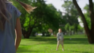 Shuttlecock raket ağına takıldı. Neşeli çocuklar yaz parkında badminton oynarlar.