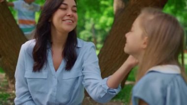 Gülümseyen anne, piknikte kızını kucaklıyor. Çocuklar annenizle eğlenin..