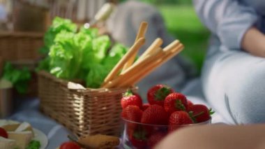 Yaz pikniğinde nefis bir öğle yemeği. Tanınmayan eller çilek alır.