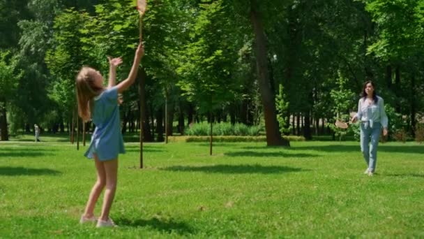 Cheerful girl playing badminton with mother in park. Active family rest concept. — Stock Video