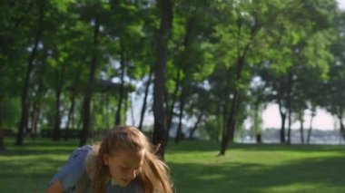 Neşeli kız altın güneş ışığı parkında raketle top fırlatıyor..