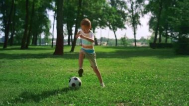 Enerjik çocuk futbol maçından önce ısınıyor. Sahaya odaklanmış çocuk oyunu.
