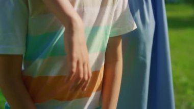 Yakından küçük kardeşe sarılan sevimli kız kardeş. Oğlum, tahta badminton raketine yaslan.