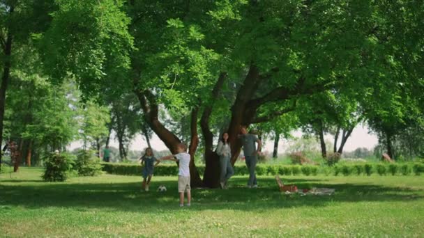 Agile Kinder beim aktiven Spielen in der Natur. Glückliche Familie genießt fröhliches Picknick. — Stockvideo