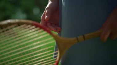 Badminton raketini elinde tutan çocuk ağları inceliyor. Etkin hobi kavramı