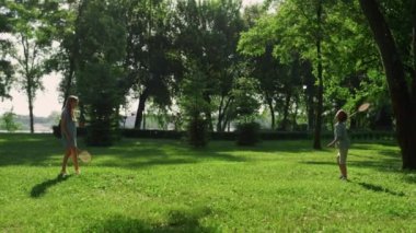 Güneşli yaz gününde badminton oynayan iki neşeli kardeş. Aile pikniği