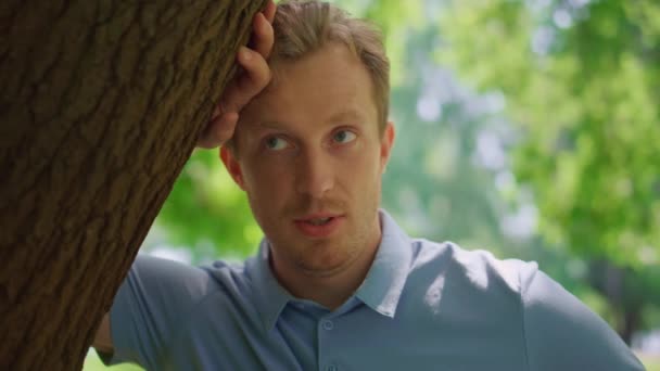 Closeup attractive man talking with woman lean on tree. Young male stand on lawn — Stock Video