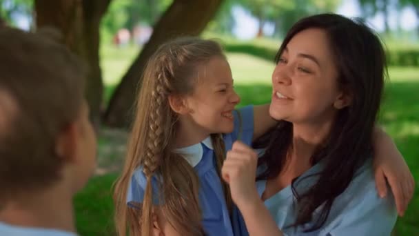 Madre sonriente abrazar a los niños en el picnic de cerca. Concepto de maternidad feliz. — Vídeo de stock