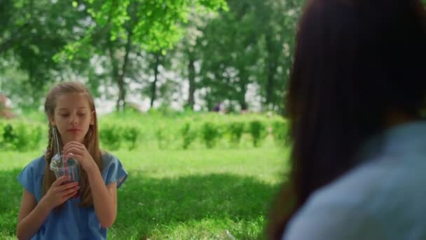 Spokojna dziewczyna trzymająca drinka na pikniku z bliska. Sok smakowy dziecka na łonie natury. — Wideo stockowe