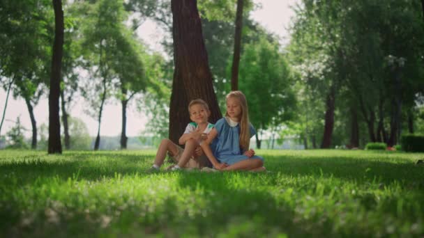 Bambini gioiosi che giocano sotto l'albero. I bambini sorridenti si divertono all'aperto nel fine settimana. — Video Stock