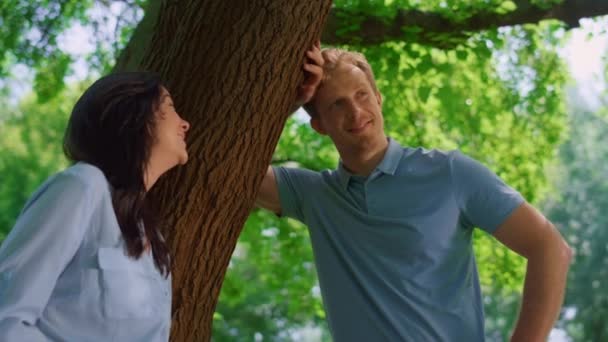 Pareja sonriente de pie en primer plano de la naturaleza. feliz pareja relajarse magra en árbol tronco. — Vídeos de Stock