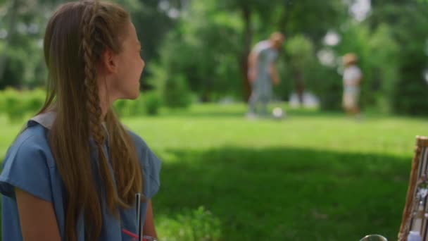 Spokojna dziewczyna oglądanie piłki nożnej szkolenia ojciec z synem na zielony trawnik zbliżenie. — Wideo stockowe