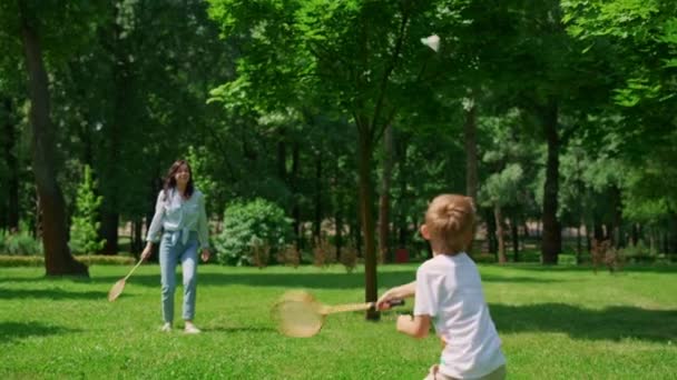 Anak laki-laki aktif bermain bulutangkis dengan pandangan belakang ibu. Olahraga dalam konsep kehidupan keluarga — Stok Video
