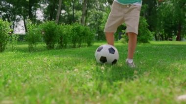 Meçhul erkek bacakları futbol antrenmanını yakından çekiyor. Oğlum babamla futbol antrenmanı yapıyor..