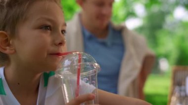 Şirin çocuk meyve suyu içerken yaklaş. Neşeli çocuk, taze içeceğin tadına bak..