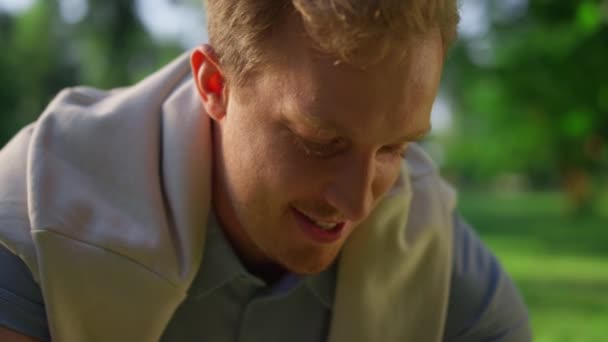 Joyful guy talking paddle in park closeup. Smiling blond man play unknown pet. — Stock Video