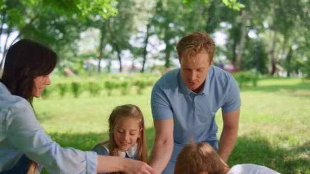 Lycklig familj förbereder picknick i parken. Aktiv sommar vila på frisk luft koncept. — Stockvideo