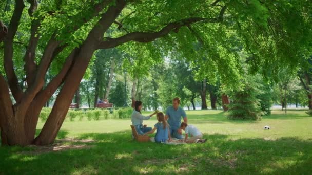 Беззаботный семейный отдых в солнечном парке. Дети веселятся с родителями на пикнике. — стоковое видео