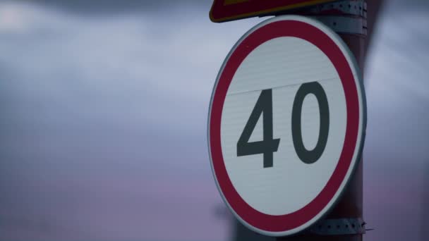 Signe de limitation de vitesse d'avertissement au gros plan du ciel violet. Plaque de contrôle du trafic municipal. — Video