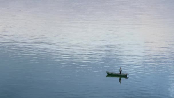 Fischer stehend Boot beobachtet Fluss Strömung Drohne erschossen. Glühende Wasseroberfläche — Stockvideo