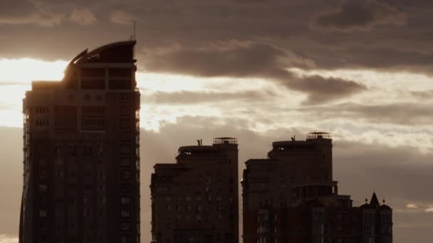 Stedelijke architectuur silhouet drone schot. Stad zonsondergang blokken flats bij bewolkte hemel — Stockvideo