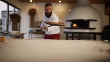 İtalyan şef restoranda pizza yapıyor. Hamur işi aşçısı yemeği fırına atıyor..
