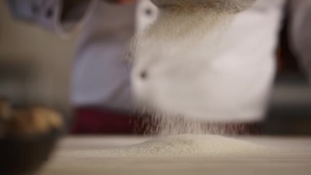 Koki profesional memasak tepung di dapur kafe. Tukang roti memilah menggunakan saringan. — Stok Video