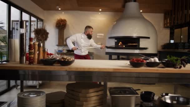 Szef kuchni człowiek gotowanie pizza włoskie jedzenie w profesjonalnej kuchni kuchenka restauracja. — Wideo stockowe
