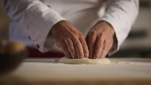 Le mani di cuoco di pasticcino impastano la pasta di pizza a bordo. Chef uomo che fa il pane in cucina. — Video Stock
