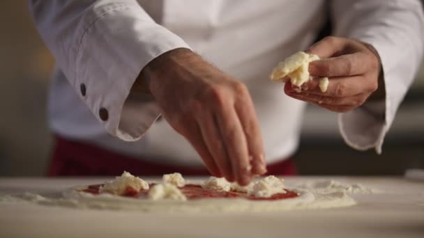 Pizzaiolo che cucina i pasti al ristorante. Le mani dell'uomo mettono la cucina di mozzarella — Video Stock