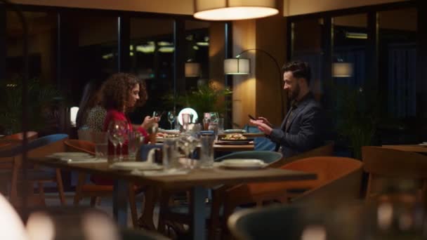 Two lovers take photo using mobile phone in restaurant. Couple enjoy dinner date — Stock Video