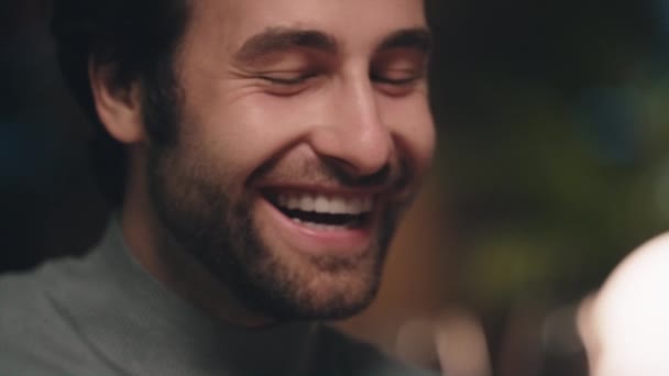 Un bel viso da uomo sorridente in luce soffusa. Ragazzo positivo godendo conversazione. — Video Stock